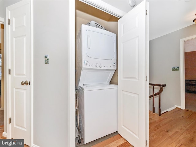 washroom featuring stacked washer / dryer and light hardwood / wood-style floors