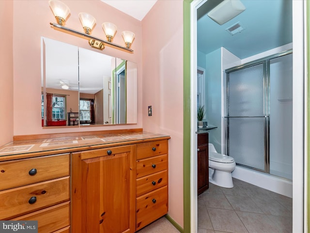 bathroom featuring walk in shower, tile patterned floors, toilet, and vanity