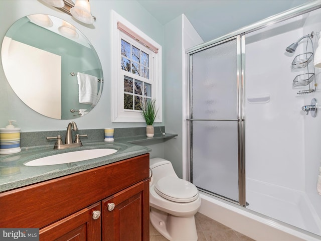 bathroom featuring vanity, toilet, a shower with shower door, and tile patterned flooring