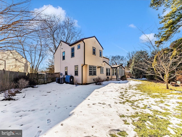 snow covered rear of property with central air condition unit