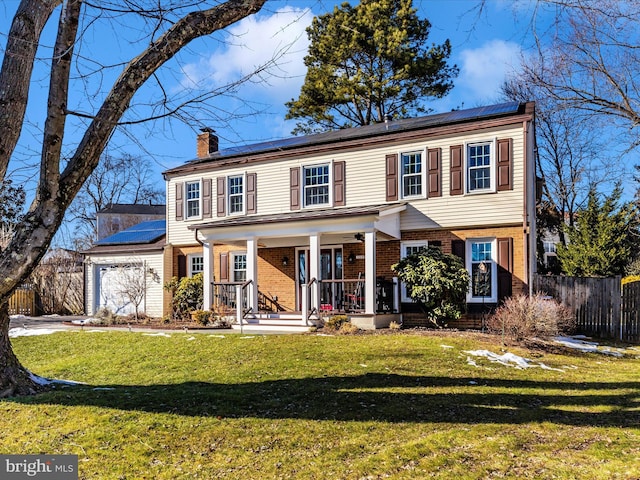 colonial house with a garage, a front lawn, covered porch, and solar panels