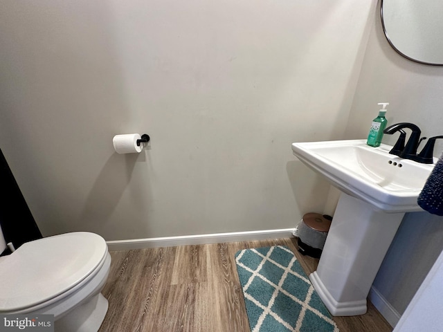 bathroom featuring hardwood / wood-style floors and toilet