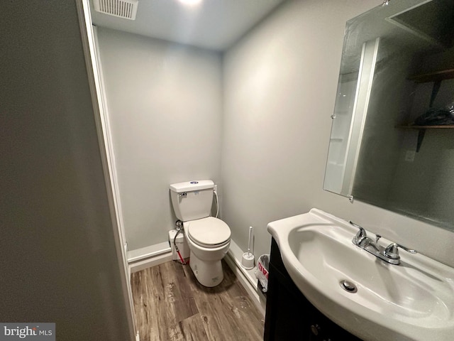 bathroom featuring vanity, wood-type flooring, and toilet