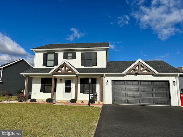 view of front of house featuring covered porch, a garage, and a front yard