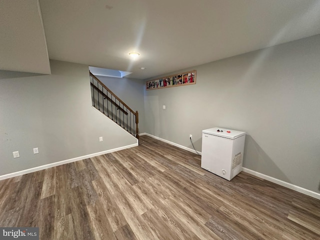 basement with wood-type flooring and refrigerator