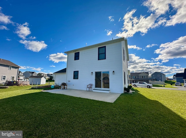 rear view of house with a patio and a lawn