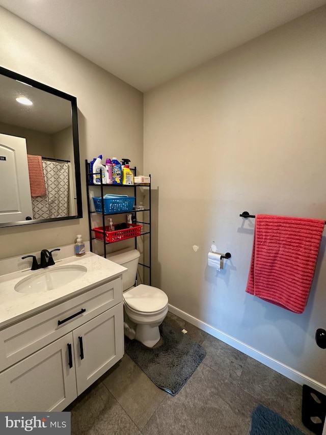 bathroom with tile patterned flooring, vanity, and toilet