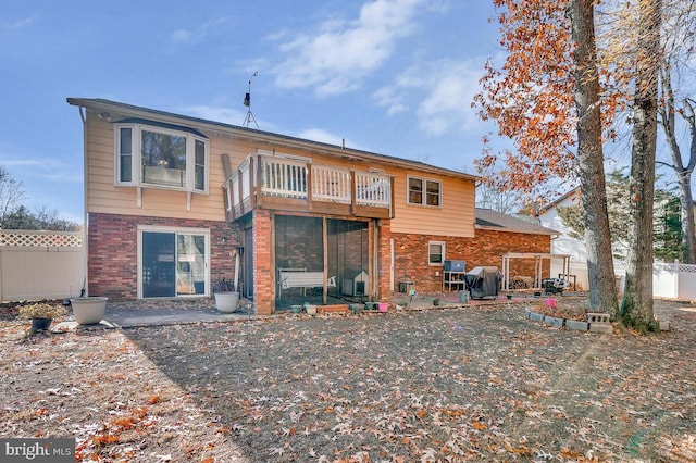 rear view of house featuring a balcony and a patio