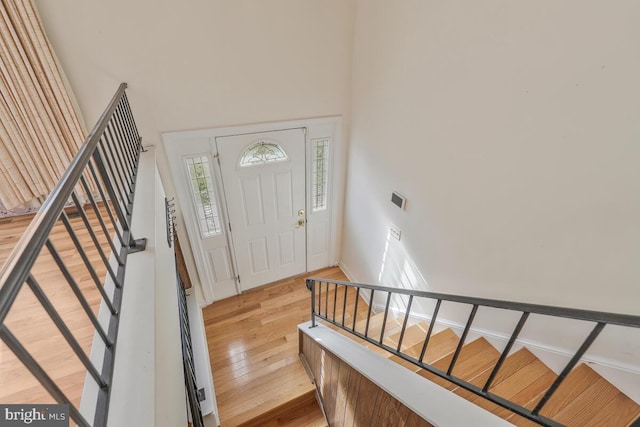 entryway featuring a towering ceiling and light hardwood / wood-style floors