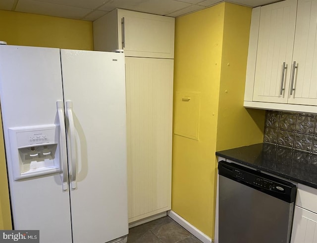 kitchen featuring white cabinets, a drop ceiling, dishwasher, and white refrigerator with ice dispenser