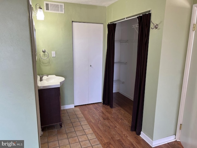 bathroom featuring hardwood / wood-style flooring, vanity, and a textured ceiling