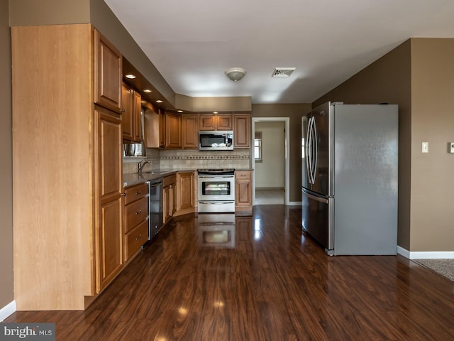 kitchen featuring dark hardwood / wood-style flooring, tasteful backsplash, sink, and stainless steel appliances