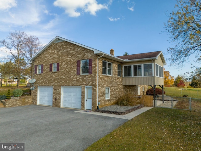 view of property exterior with a garage and a sunroom