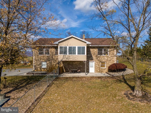 rear view of property with a lawn and a patio