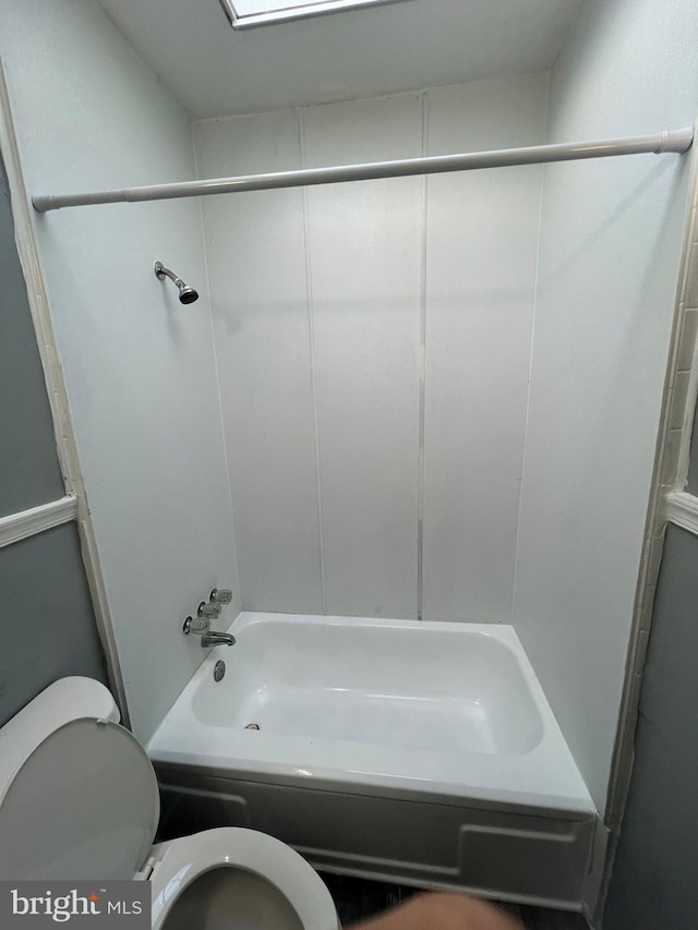 bathroom with toilet and bathing tub / shower combination