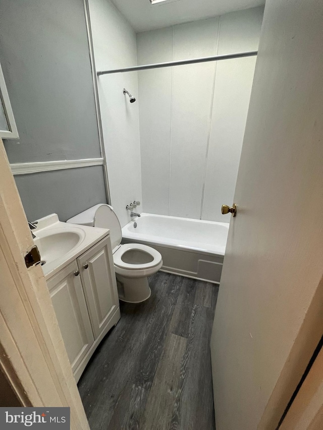 full bathroom with shower / bathing tub combination, vanity, hardwood / wood-style flooring, and toilet