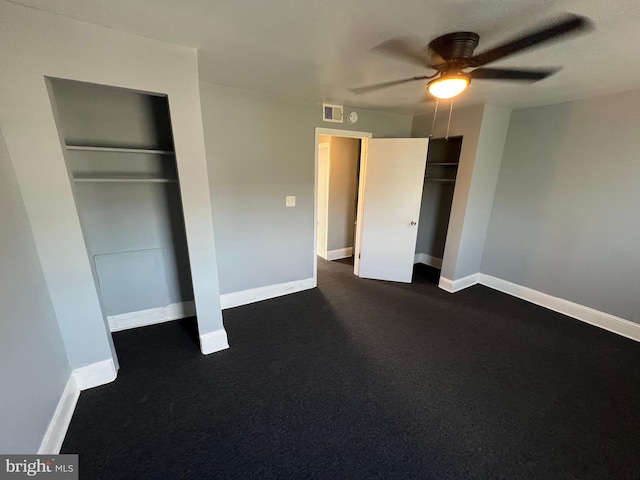 unfurnished bedroom with ceiling fan and dark colored carpet