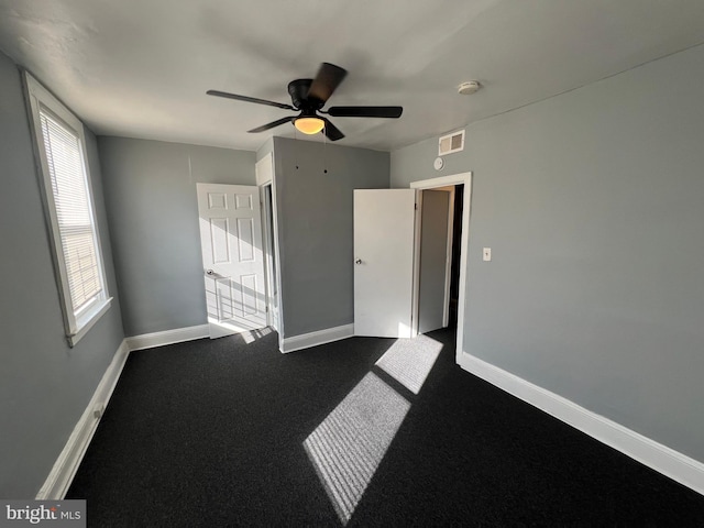 unfurnished room featuring ceiling fan and carpet