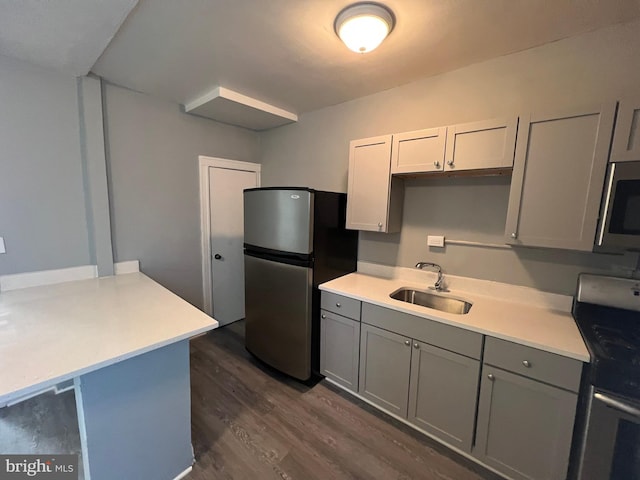 kitchen with dark wood-type flooring, gray cabinetry, sink, and appliances with stainless steel finishes