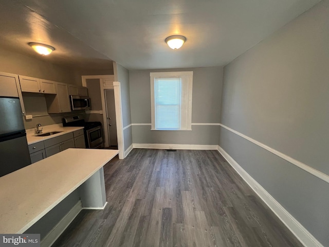 kitchen with dark wood-type flooring, gray cabinets, sink, and appliances with stainless steel finishes