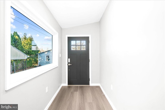 foyer with light hardwood / wood-style floors and vaulted ceiling