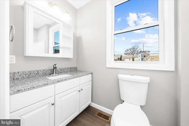 bathroom featuring vanity, wood-type flooring, and toilet