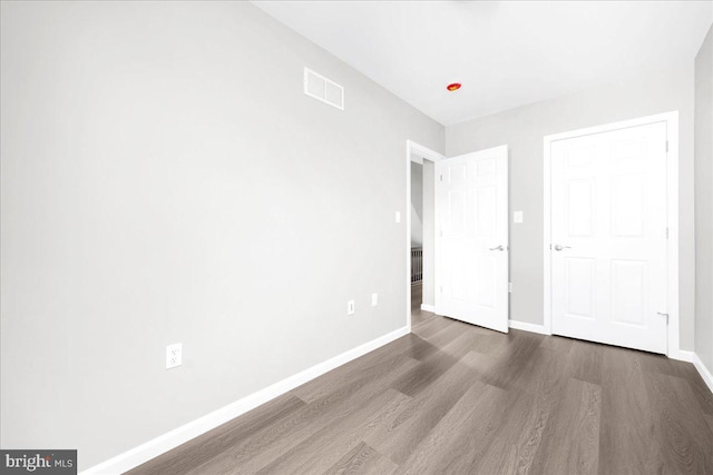 unfurnished bedroom with dark wood-type flooring