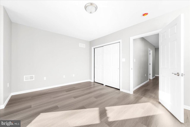 unfurnished bedroom with a closet and hardwood / wood-style flooring