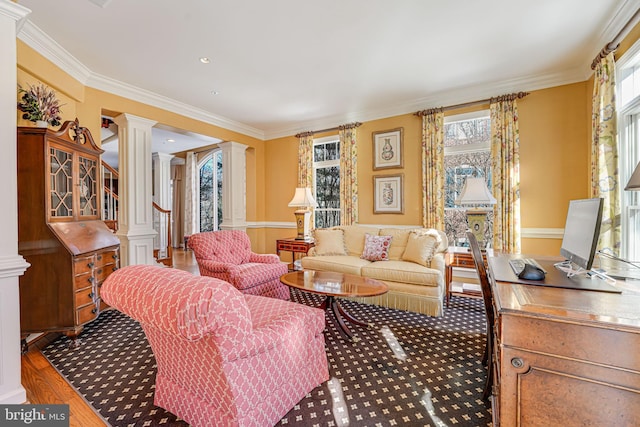 living room featuring hardwood / wood-style flooring, ornate columns, and crown molding