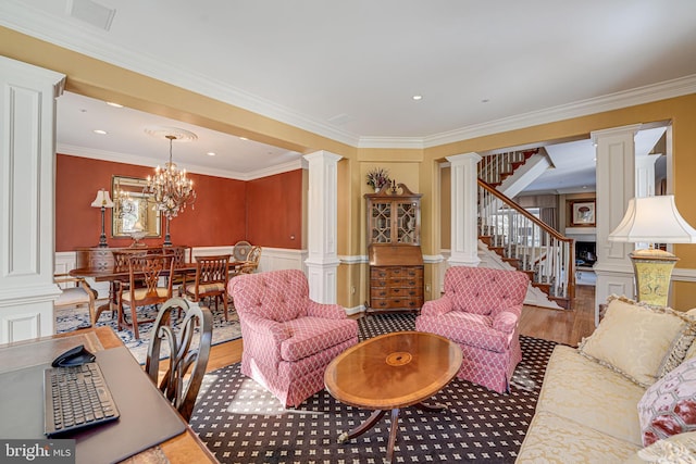 living room with decorative columns, hardwood / wood-style floors, and ornamental molding