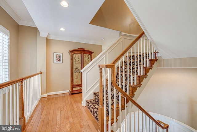 stairway featuring wood-type flooring and ornamental molding