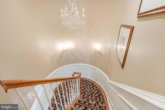 stairway featuring a chandelier