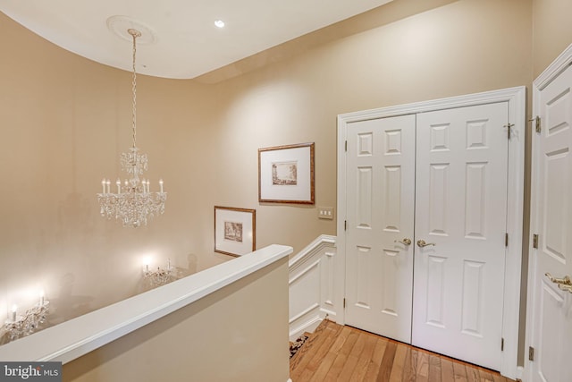 hall featuring a notable chandelier and light hardwood / wood-style flooring