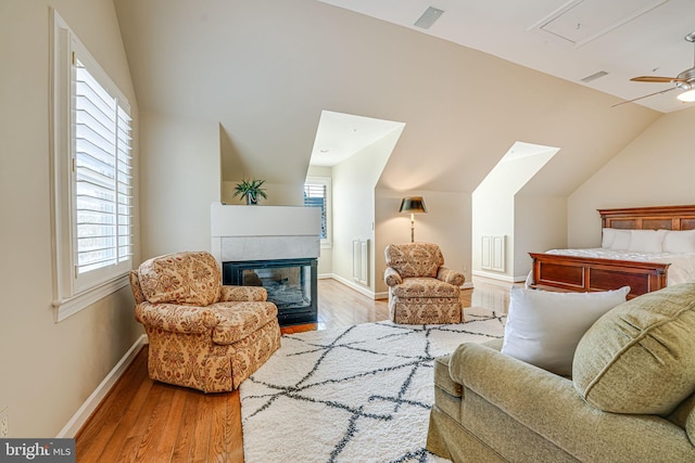 sitting room featuring a fireplace, lofted ceiling, and light wood-type flooring