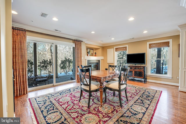 dining space featuring light hardwood / wood-style flooring and ornamental molding