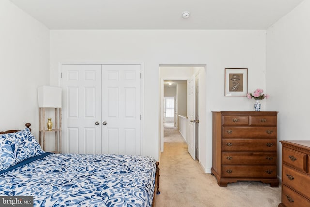 bedroom featuring light carpet and a closet