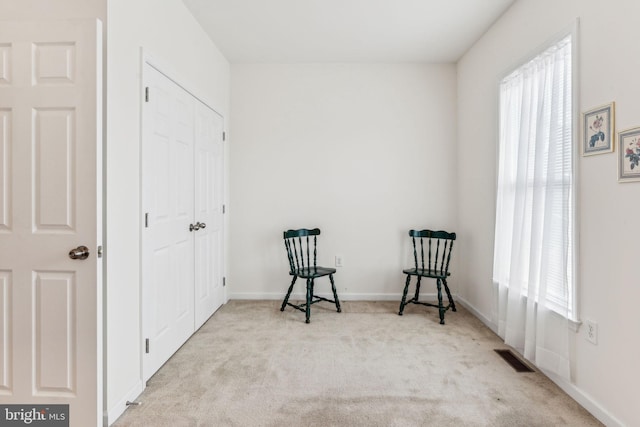 sitting room with plenty of natural light and light colored carpet