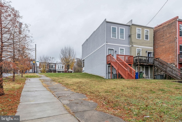 back of property featuring a yard and a wooden deck