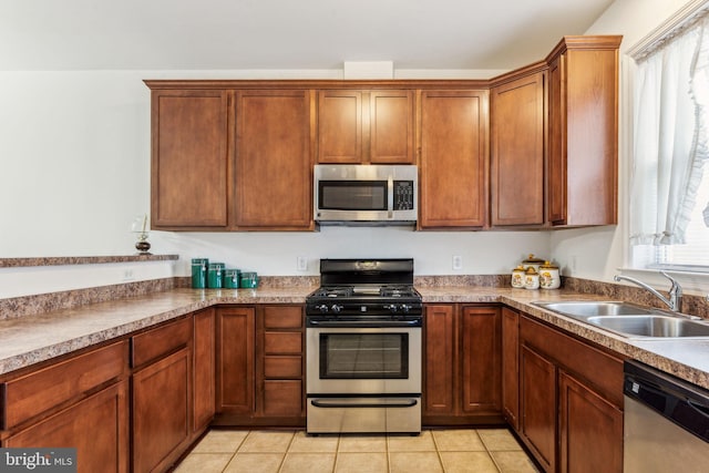 kitchen featuring light tile patterned floors, stainless steel appliances, and sink