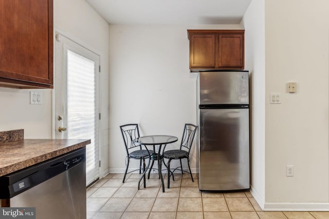 kitchen with light tile patterned flooring and appliances with stainless steel finishes