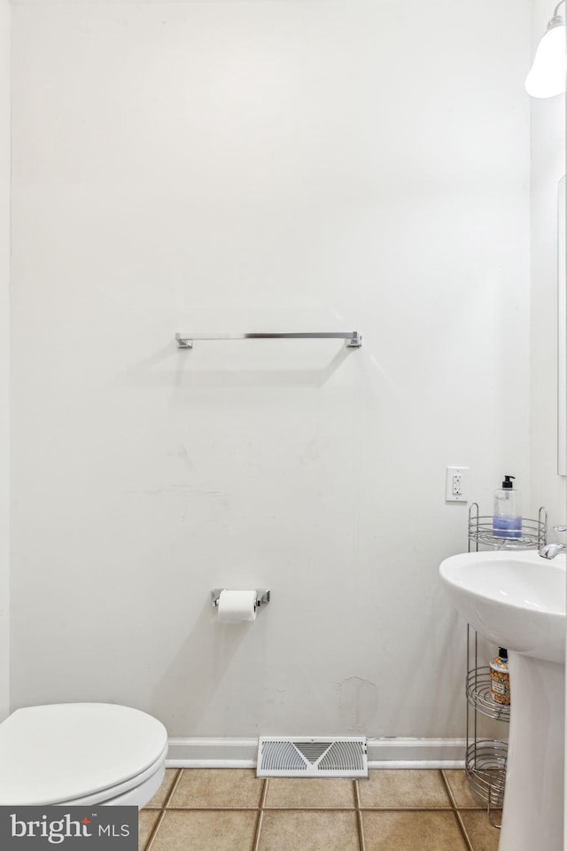 bathroom featuring tile patterned flooring, toilet, and sink