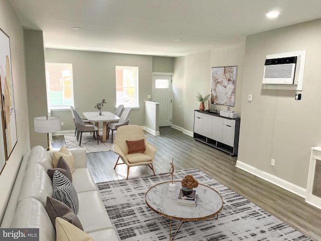 living room with an AC wall unit and light wood-type flooring