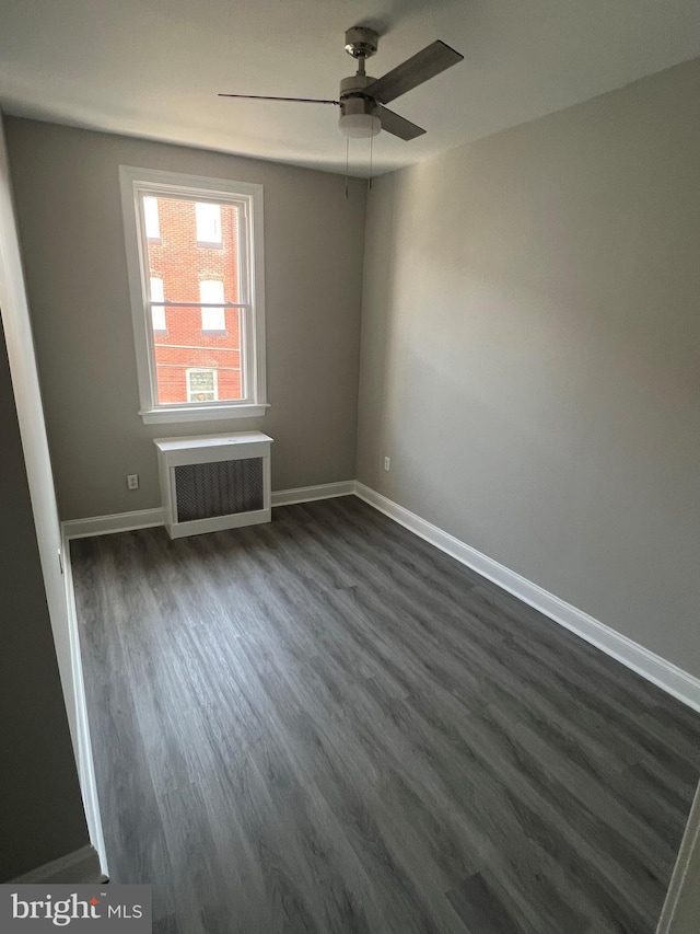 unfurnished room featuring dark wood-type flooring, radiator, and ceiling fan