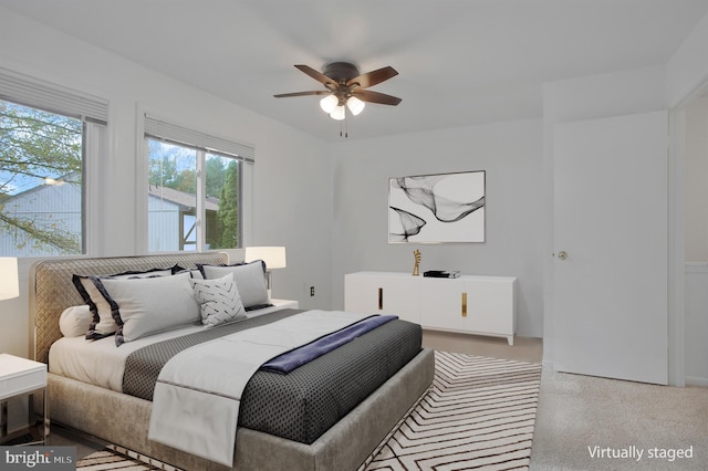 bedroom with ceiling fan and light carpet