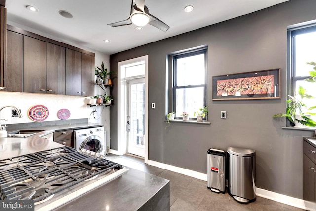 kitchen featuring dark brown cabinetry, sink, a healthy amount of sunlight, and washer / dryer