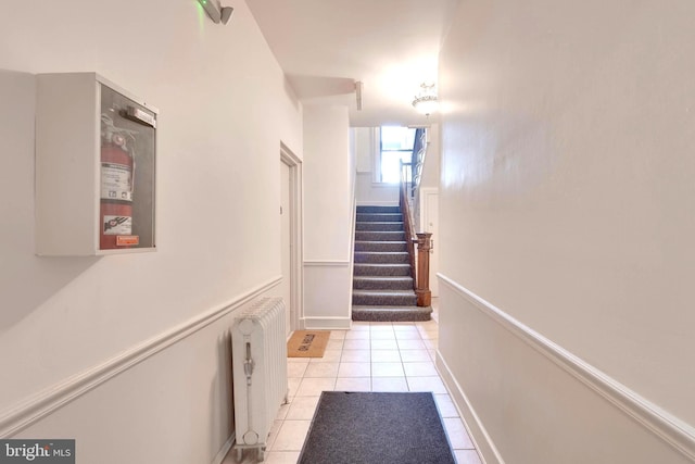 corridor with radiator heating unit and light tile patterned flooring