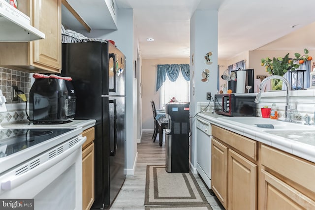 kitchen with backsplash, sink, tile countertops, white appliances, and light hardwood / wood-style flooring