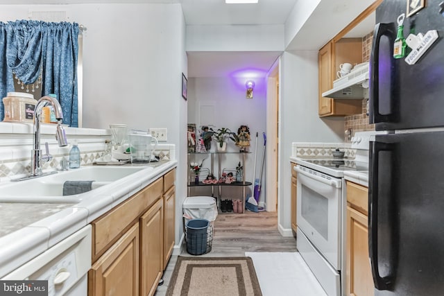 kitchen featuring white appliances, sink, light wood-type flooring, and exhaust hood