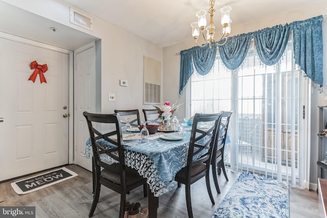 dining room with hardwood / wood-style floors and a chandelier