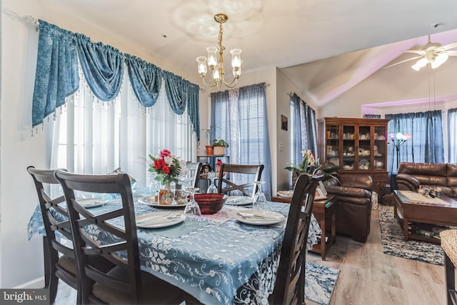 dining room with light hardwood / wood-style floors and ceiling fan with notable chandelier